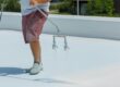 Man spraying a roof with a coating