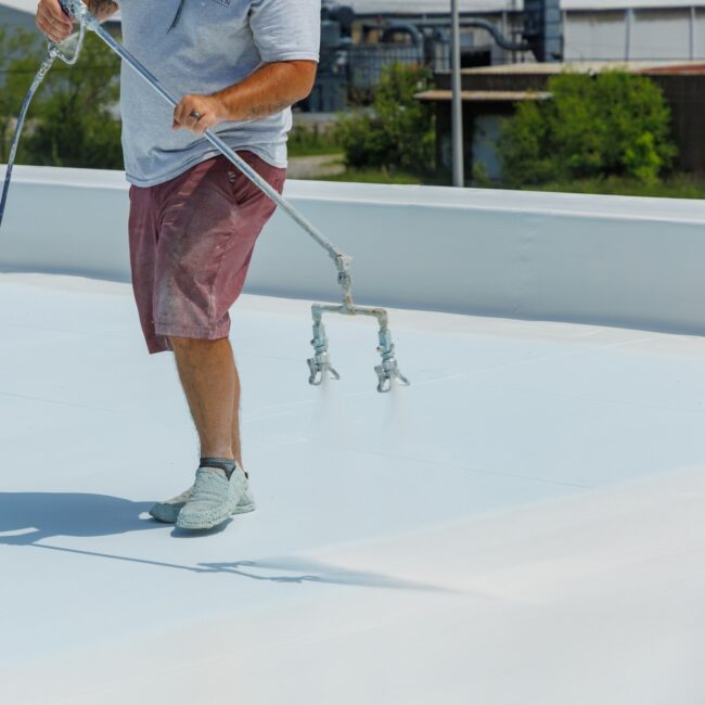 man spraying a roof Man spraying a roof with a coating