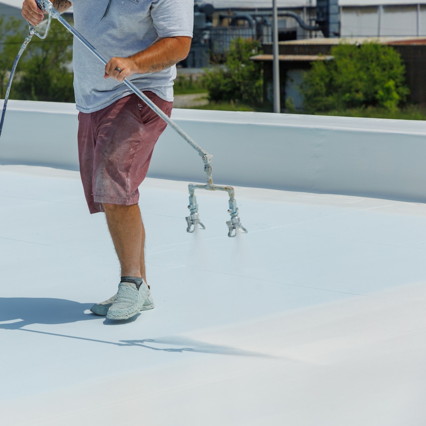Man spraying a roof with a coating