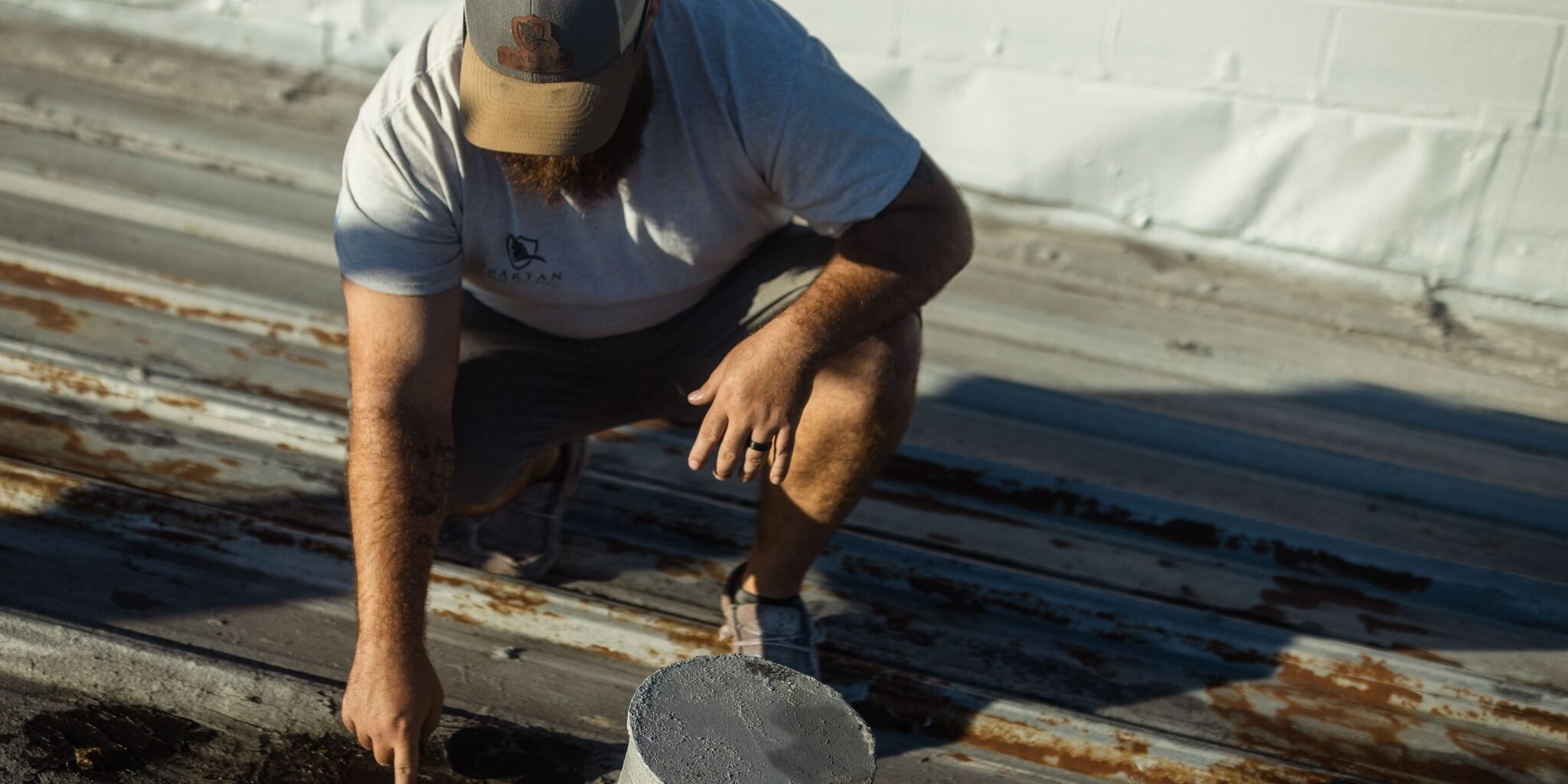 Man touching a worn roof.