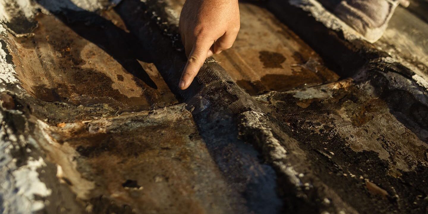 Man pointing at a damaged area of a roof