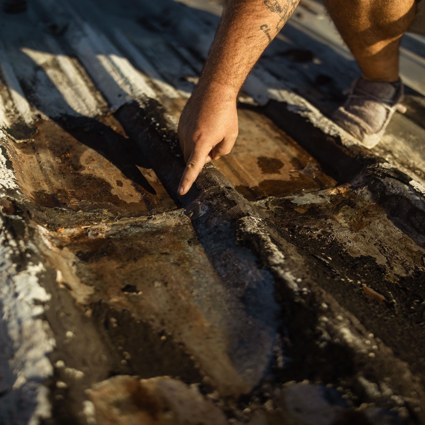 Man pointing at a damaged area of a roof